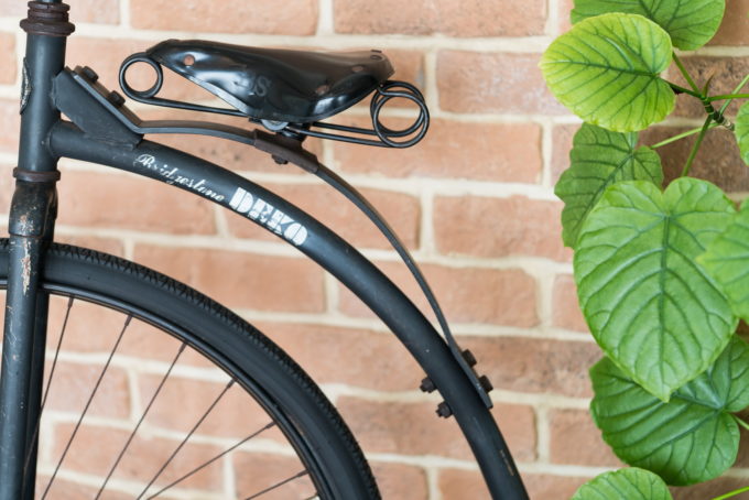 アンティークな自転車の飾り物と緑の葉っぱ