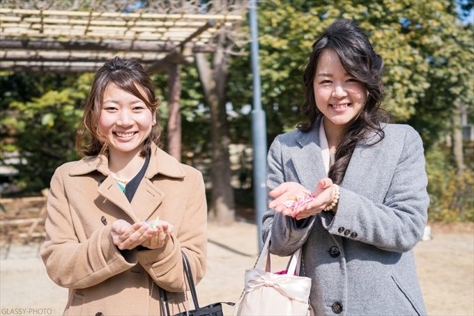 フラワーシャワーの花びらを持って笑顔の友達