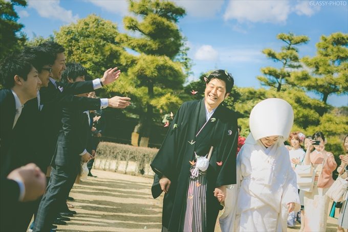 フラワーシャワーを浴びせられ笑顔の新郎さん