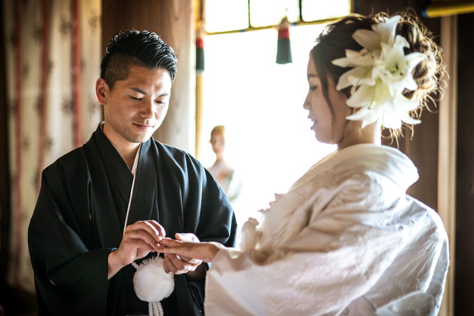 花嫁の指にリングをはめる新郎