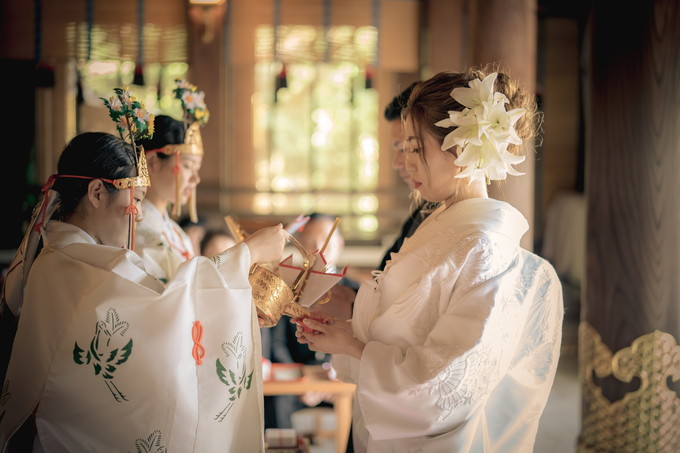 盃のお酒を受ける花嫁