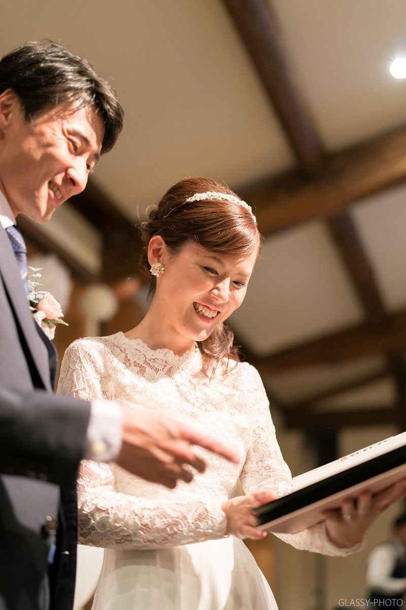 お友達からのお祝いプレゼントを楽しそうに見る新郎新婦